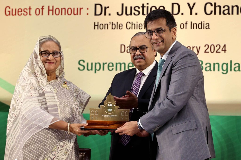 D. Y. Chandrachud in a grey suit receiving a memento from Sheikh Hasina