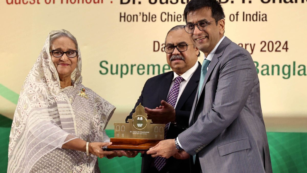 D. Y. Chandrachud in a grey suit receiving a memento from Sheikh Hasina