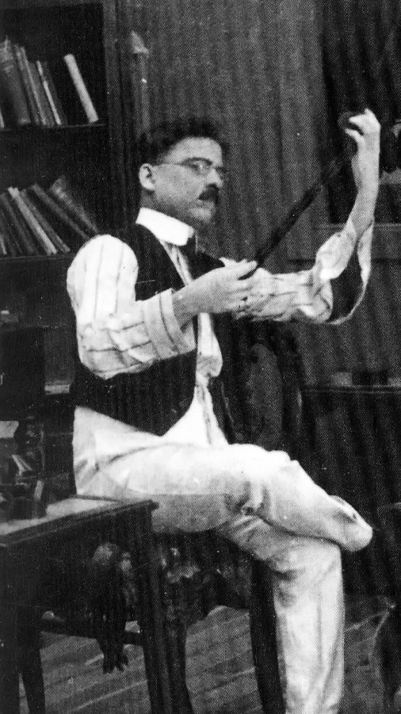 Dadasaheb Phalke seated on a chair examining a strip of film