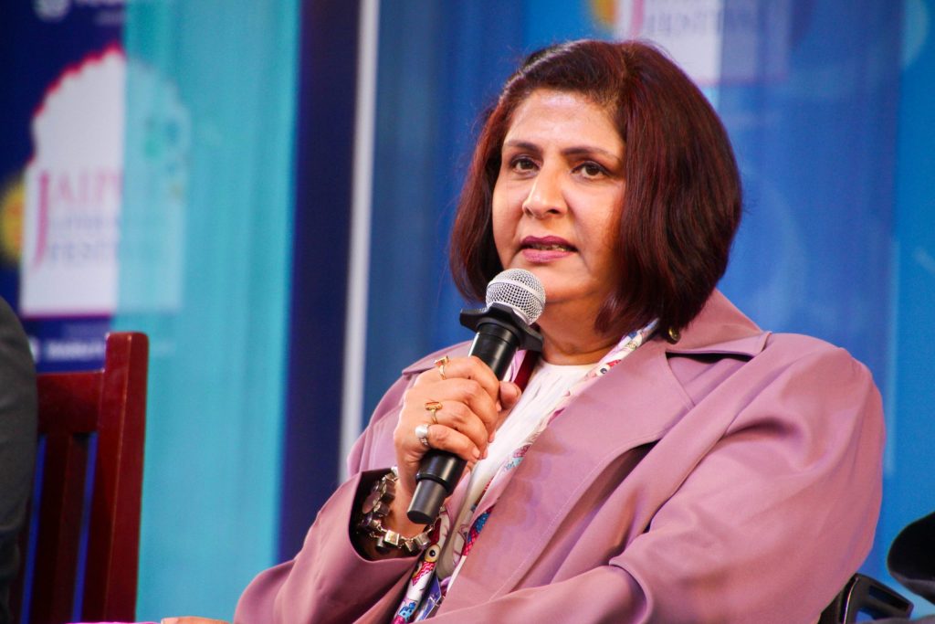 Deepa Malik in a mauve jacket speaking into a microphone