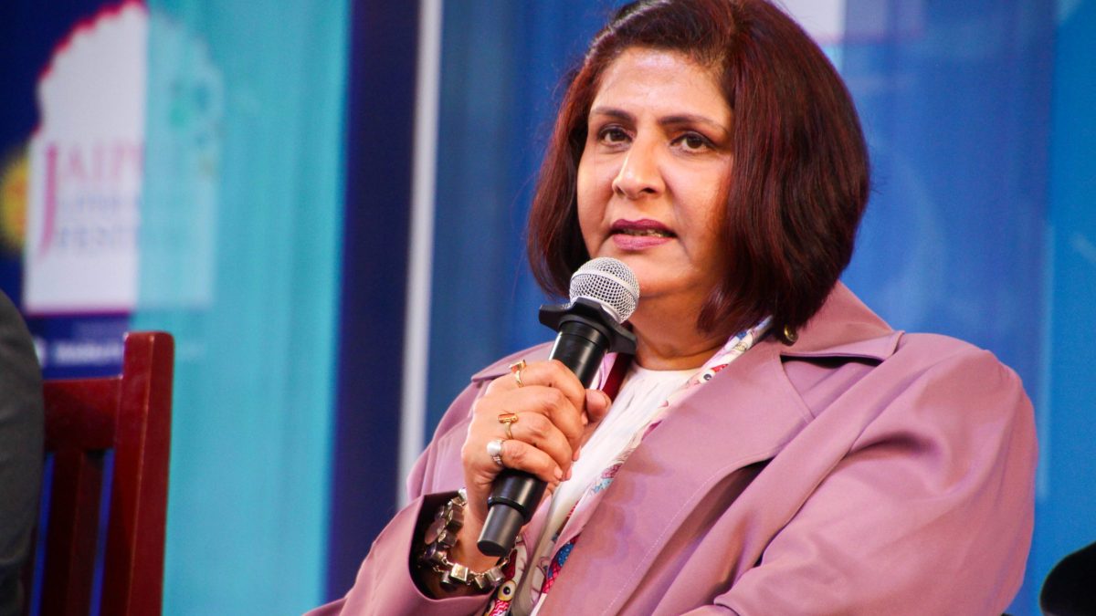 Deepa Malik in a mauve jacket speaking into a microphone