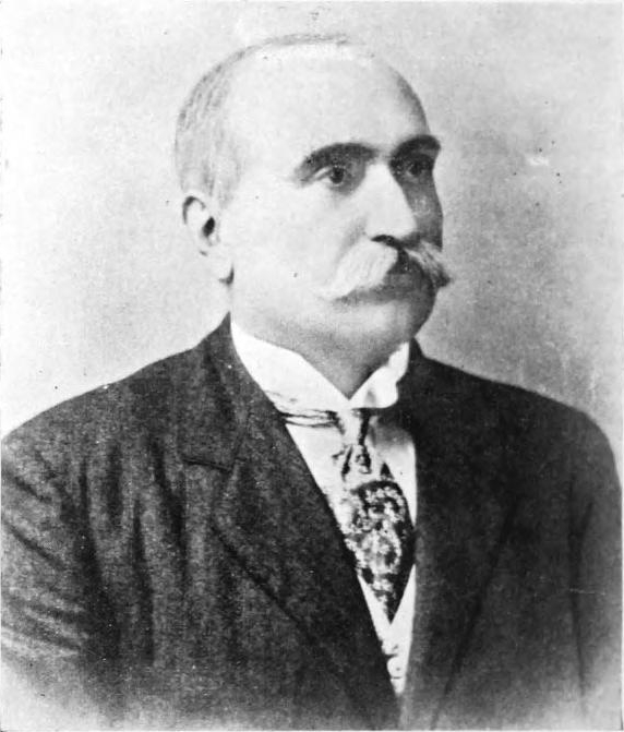 A black-and-white portrait of Sir Dorabji Tata with a moustache, in a dark suit