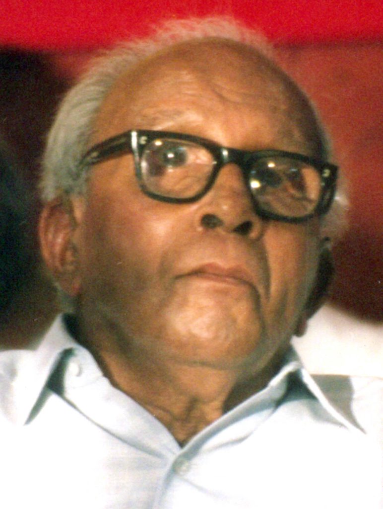 Close-up of E. M. S. Namboodiripad in thick black-framed glasses and a white shirt