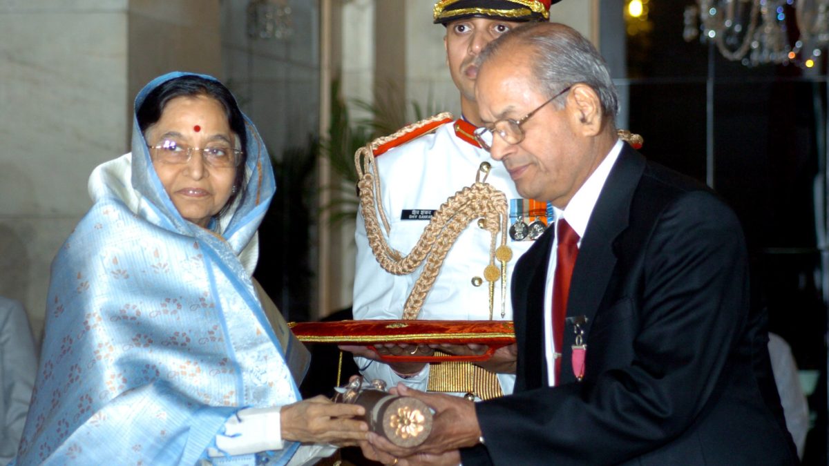 E. Sreedharan in a dark suit receiving the Padma Vibhushan from President Pratibha Patil