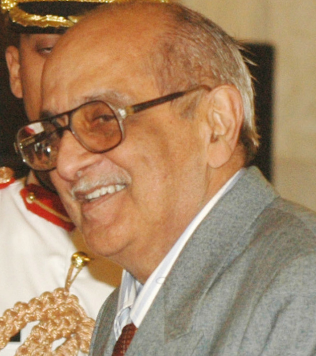 Fali Nariman in glasses and a grey suit, smiling