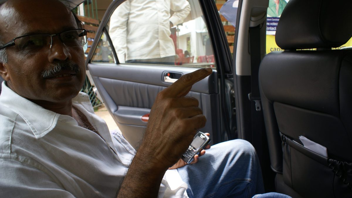Captain G. R. Gopinath seated in a car, in glasses and a white shirt
