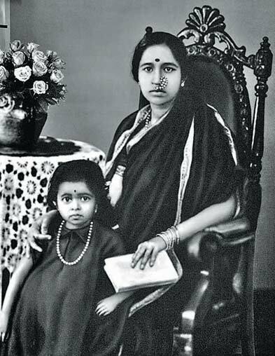 A black-and-white photograph of the young Gangubai Hangal seated, with her small daughter beside her