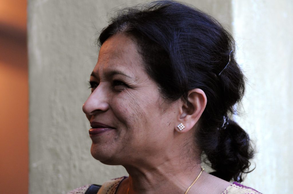 Gauri Lankesh in profile, smiling, with her hair tied back
