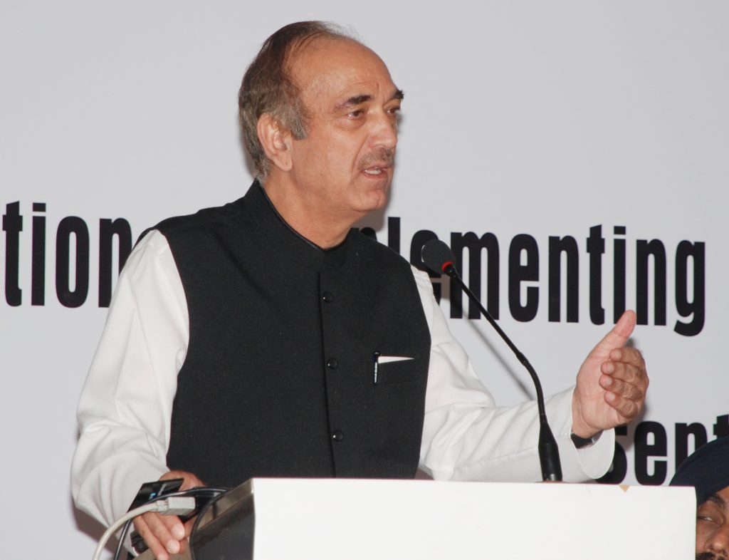 Ghulam Nabi Azad in a dark waistcoat speaking at a lectern