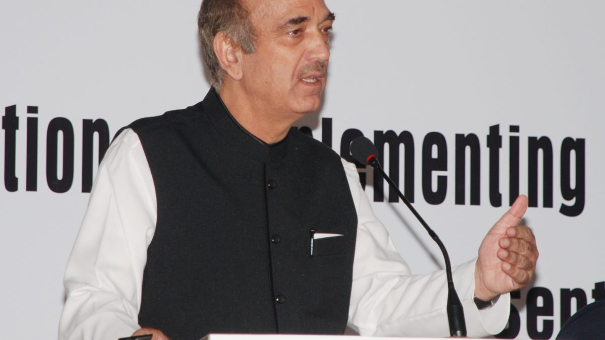 Ghulam Nabi Azad in a dark waistcoat speaking at a lectern