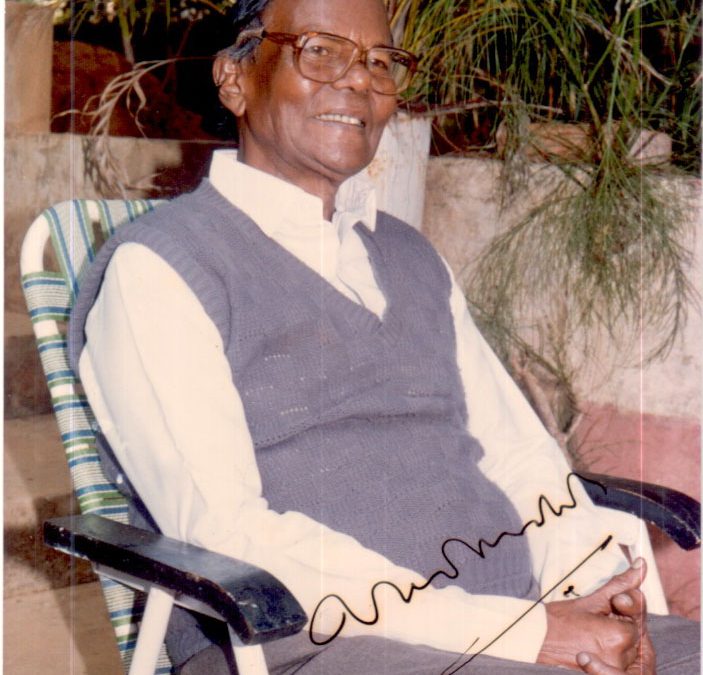 Gopinath Mohanty in glasses and a sleeveless sweater, seated in a garden chair