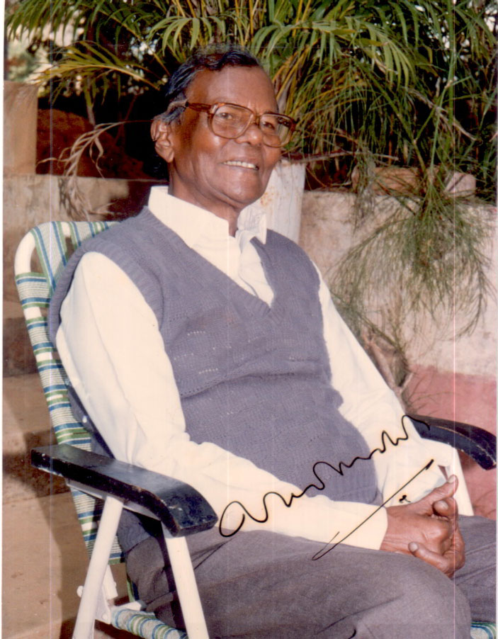 Gopinath Mohanty in glasses and a sleeveless sweater, seated in a garden chair