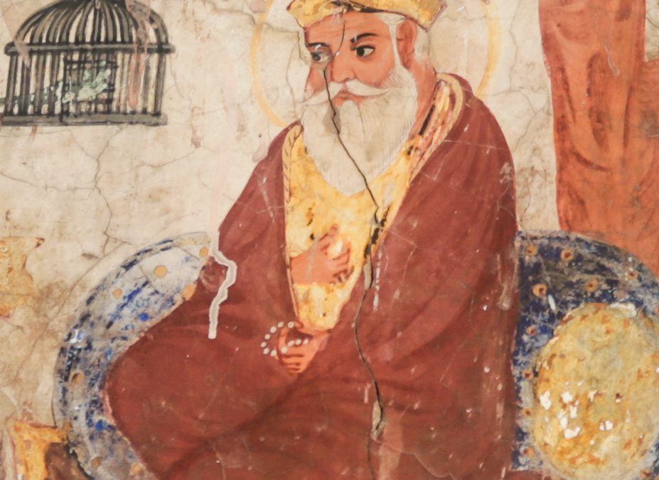 A mural painting of Guru Nanak seated with a halo, attended by companions
