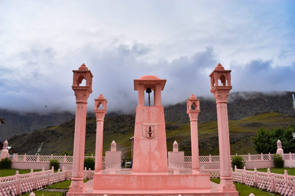 The pink sandstone Kargil War Memorial at Dras in Ladakh with mountains behind it