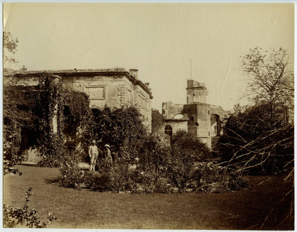 An old photograph of the ruined Residency buildings at Lucknow among trees
