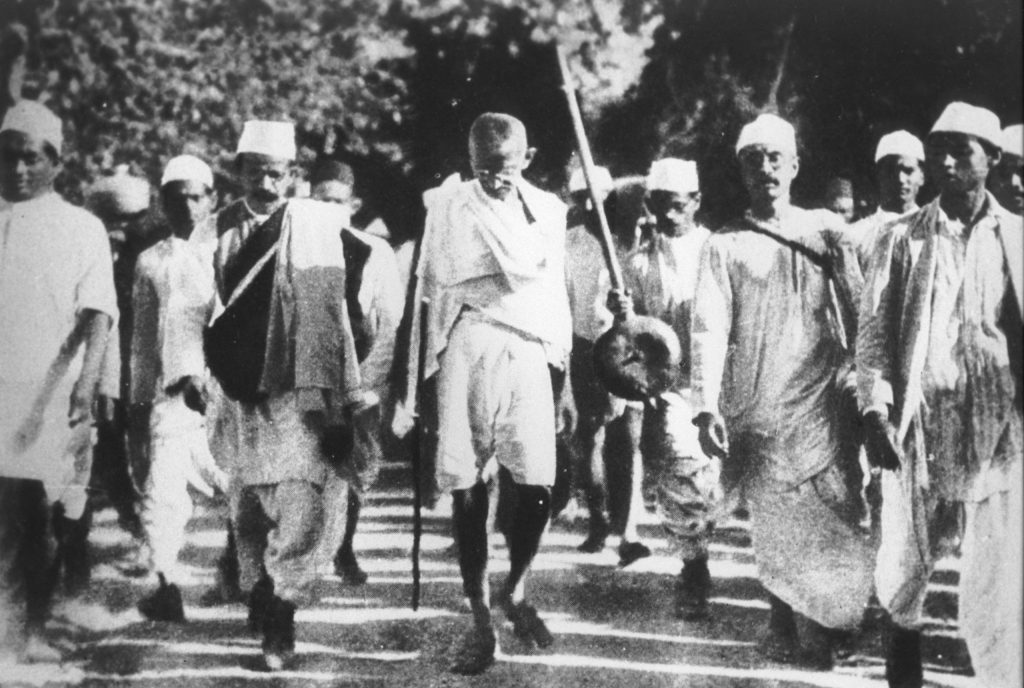 Mahatma Gandhi walking with a staff at the head of marchers during the Salt March in March 1930