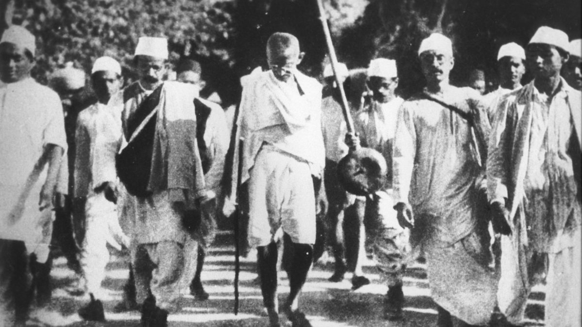 Mahatma Gandhi walking with a staff at the head of marchers during the Salt March in March 1930