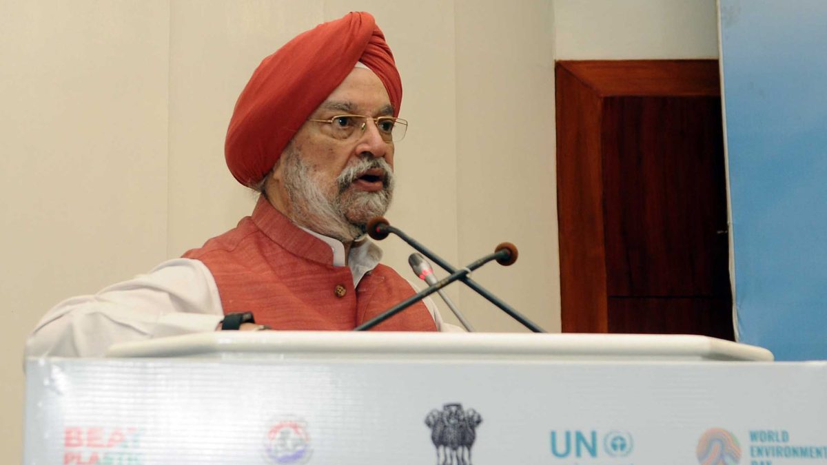 Hardeep Singh Puri in a red turban speaking at a lectern