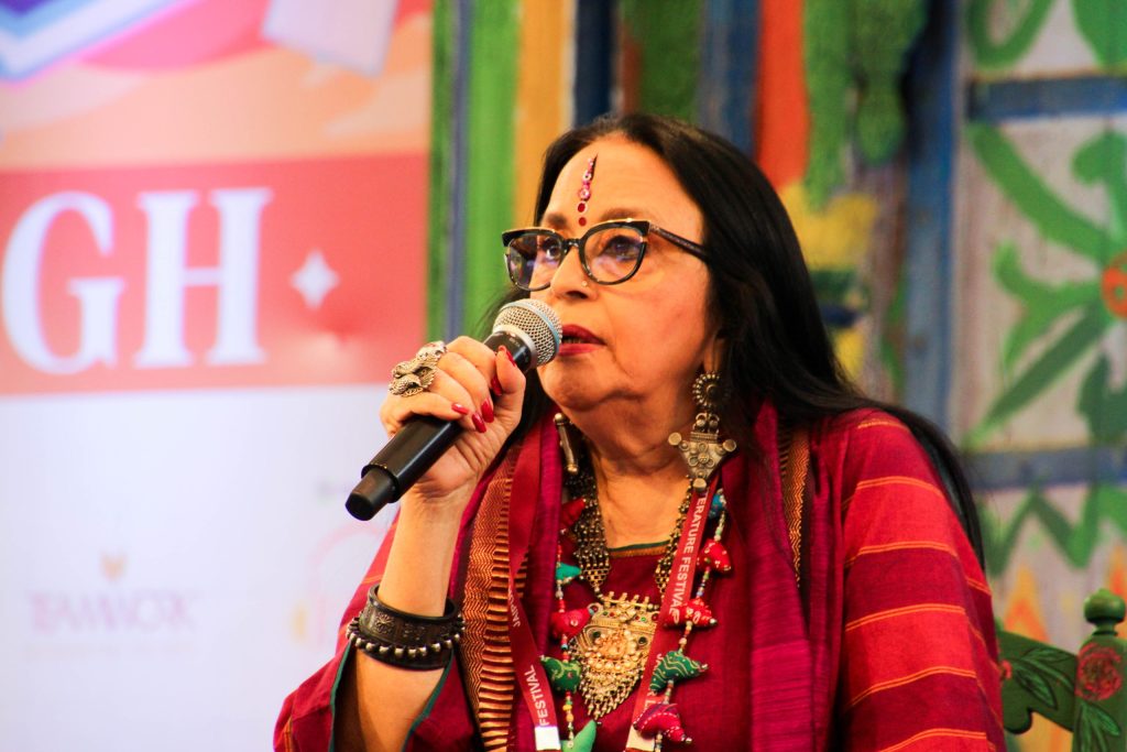 Ila Arun in a red and black outfit with silver jewellery, singing into a microphone