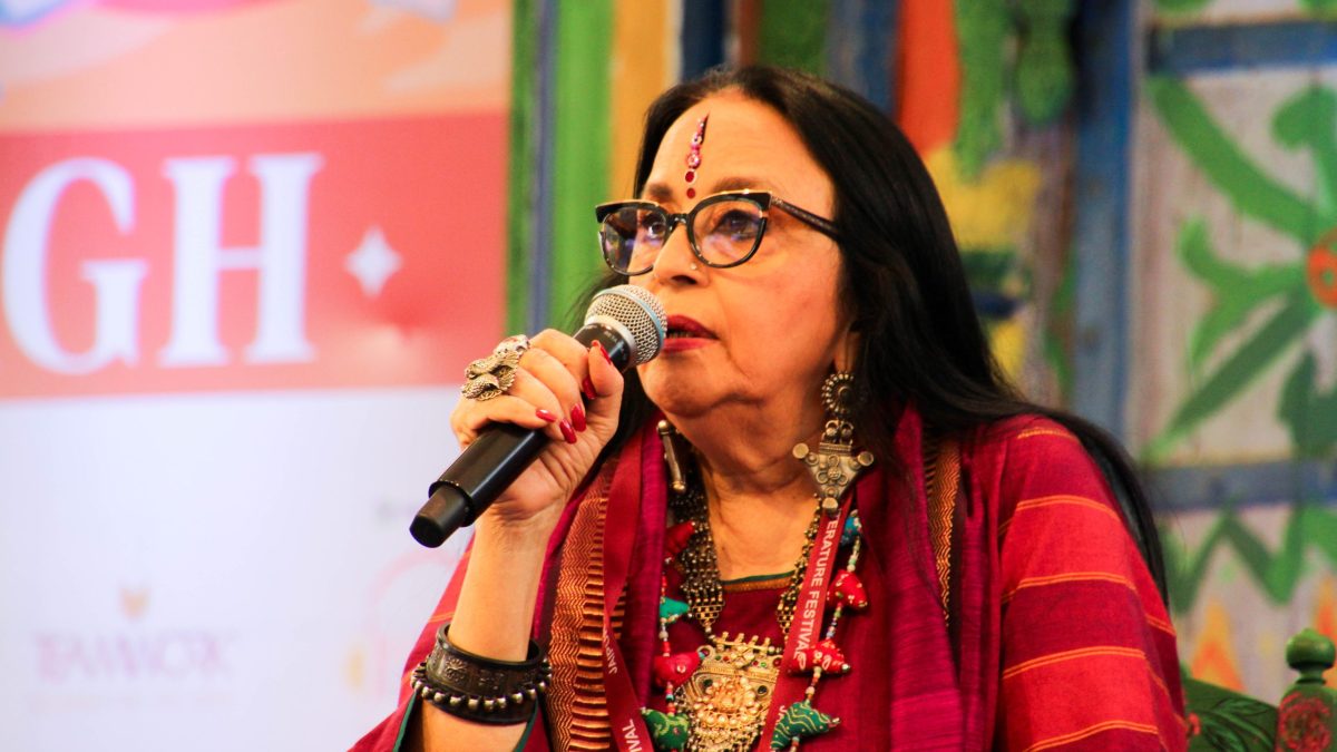 Ila Arun in a red and black outfit with silver jewellery, singing into a microphone