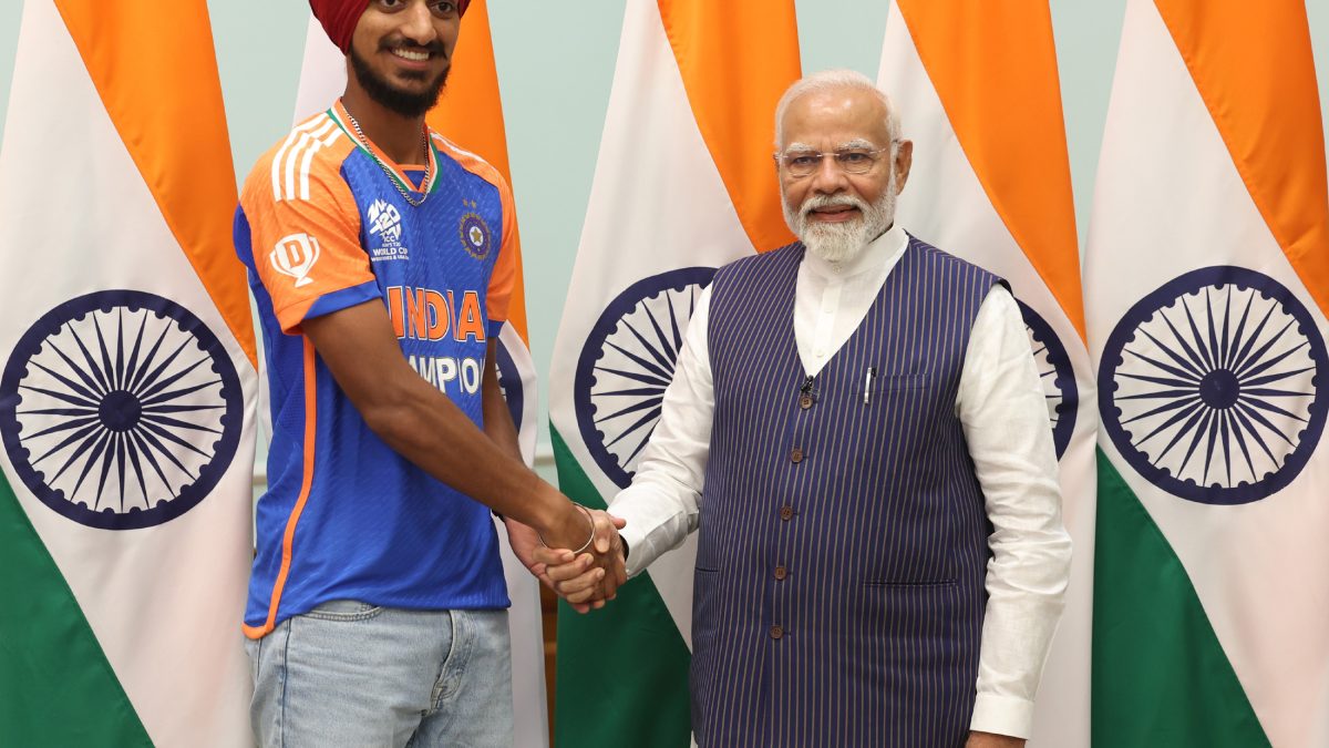 Arshdeep Singh in an India jersey shaking hands with Prime Minister Narendra Modi