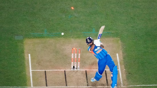 An India batter plays a shot in a match, seen from above, with the stumps and ball in view