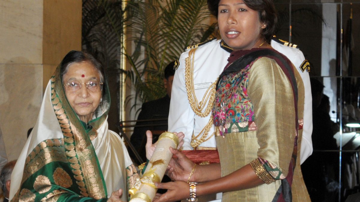 Jhulan Goswami in an embroidered outfit receiving the Padma Shri from President Pratibha Patil