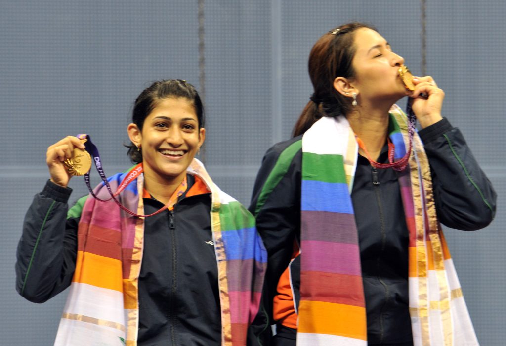 Jwala Gutta and Ashwini Ponnappa smiling and holding up their gold medals