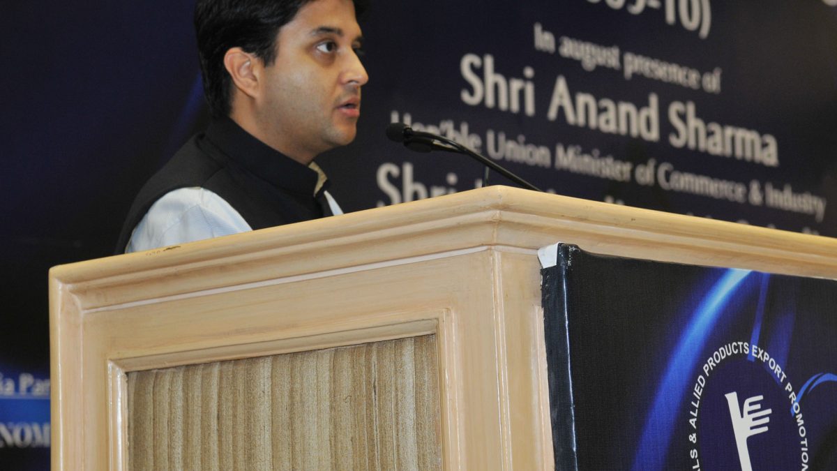 Jyotiraditya Scindia in a dark bandhgala speaking at a lectern