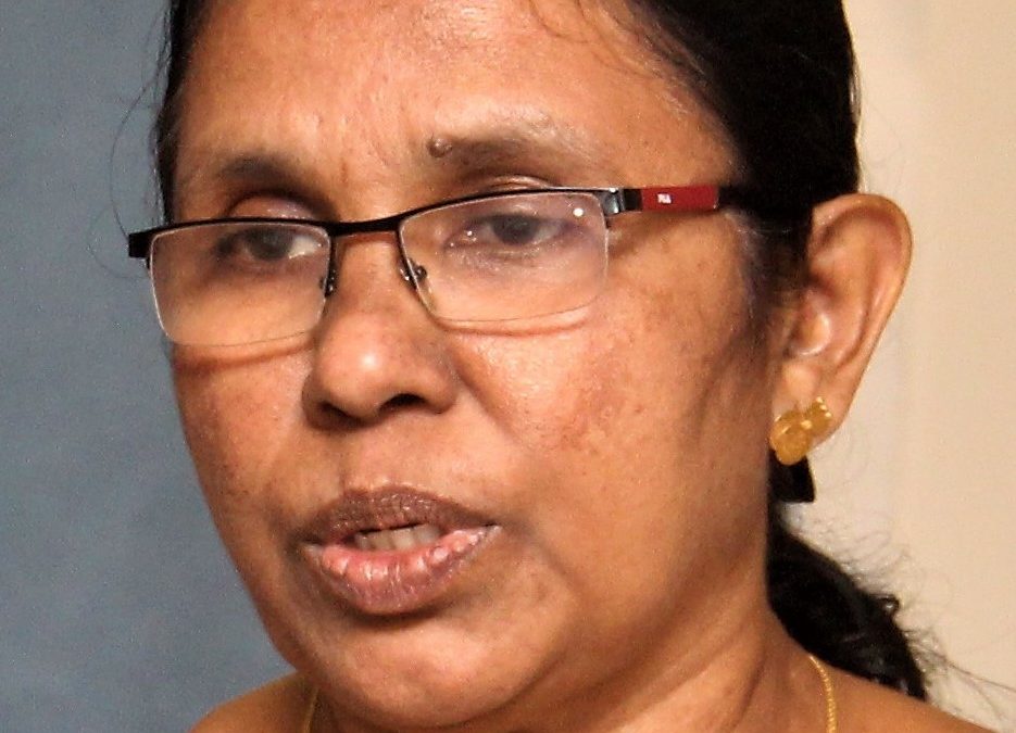 K. K. Shailaja in glasses speaking into a microphone