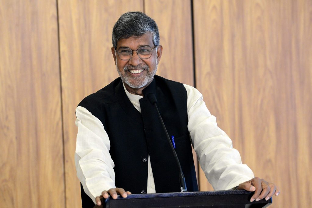 Kailash Satyarthi smiling at a podium during a press conference