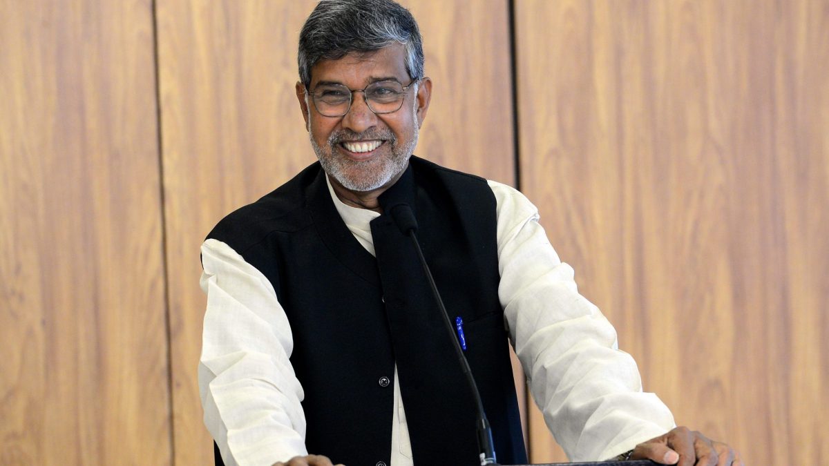 Kailash Satyarthi smiling at a podium during a press conference