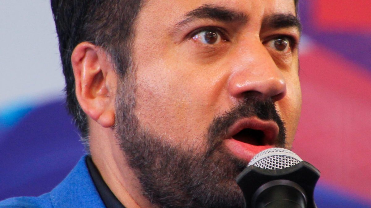 Kal Penn in glasses, smiling, at a literature festival