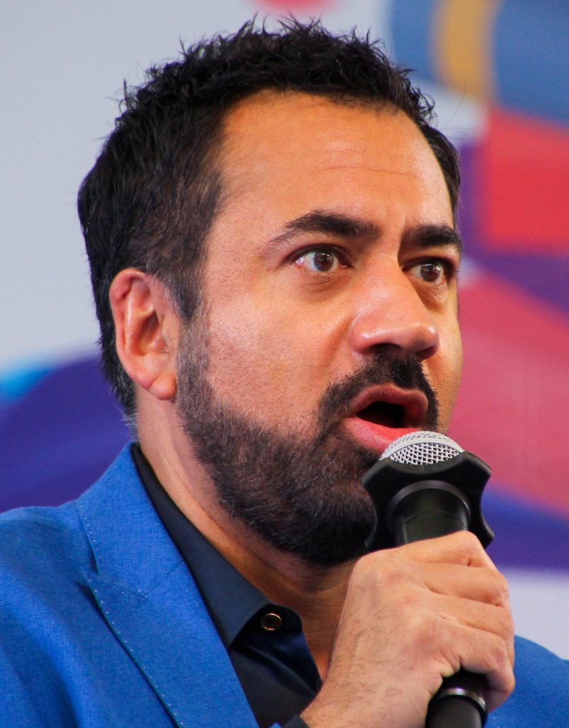 Kal Penn in glasses, smiling, at a literature festival