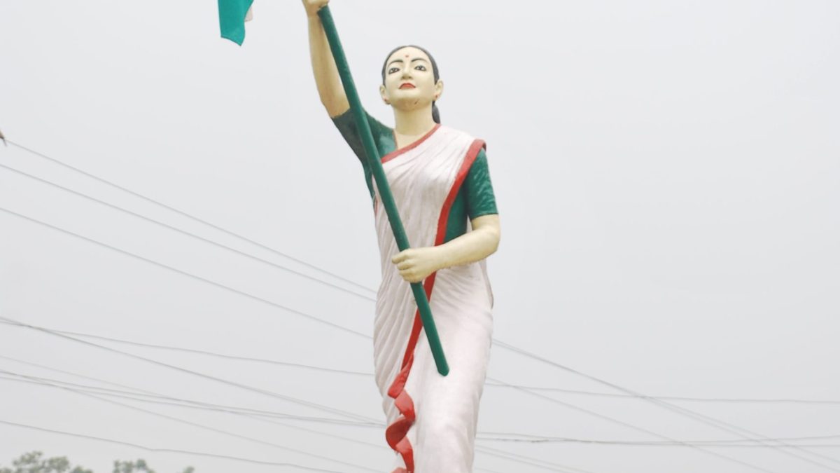 A statue of Kanaklata Barua holding the national flag