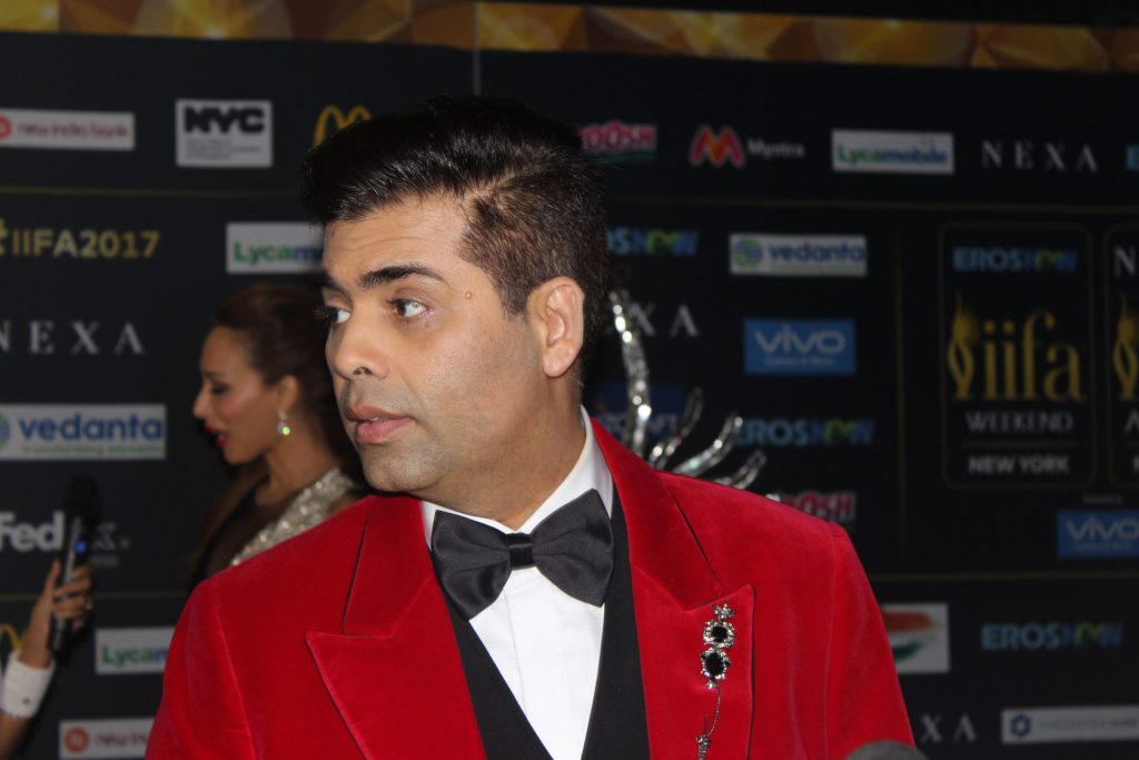 Karan Johar in a red velvet tuxedo jacket on the IIFA green carpet