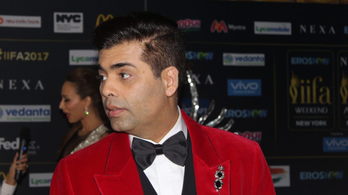 Karan Johar in a red velvet tuxedo jacket on the IIFA green carpet