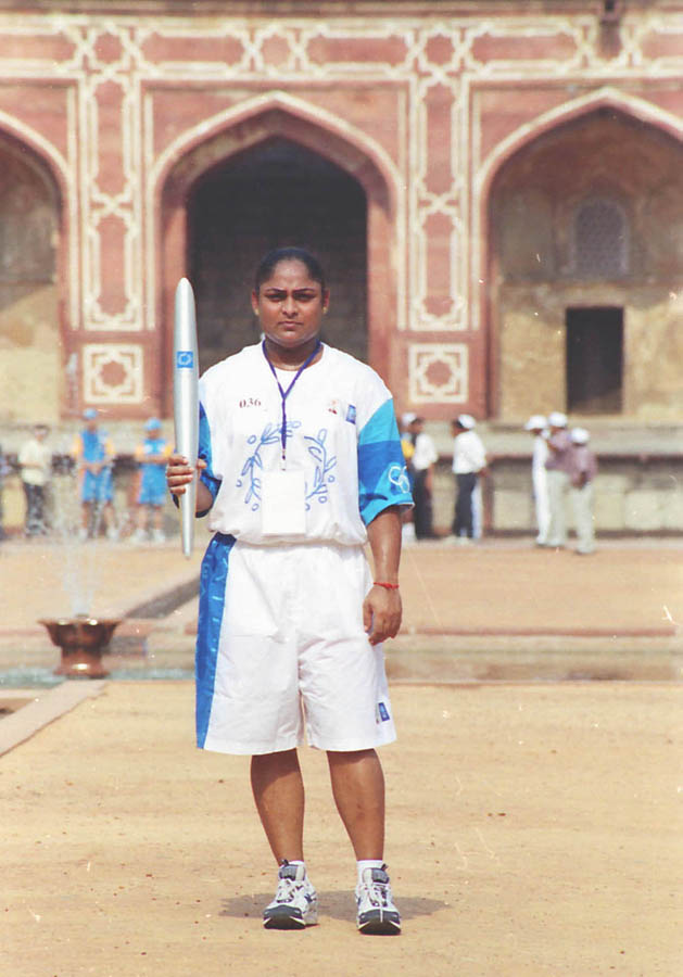 Karnam Malleswari holding the Olympic torch during a relay in New Delhi