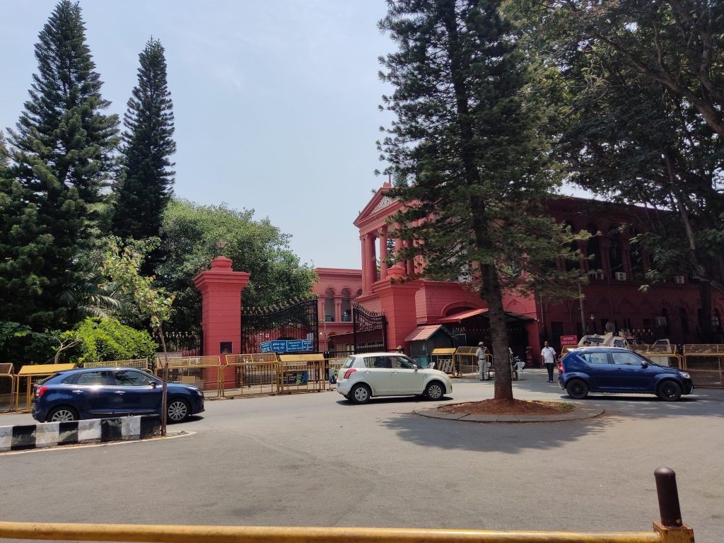 The red High Court of Karnataka building seen across a road in Bengaluru