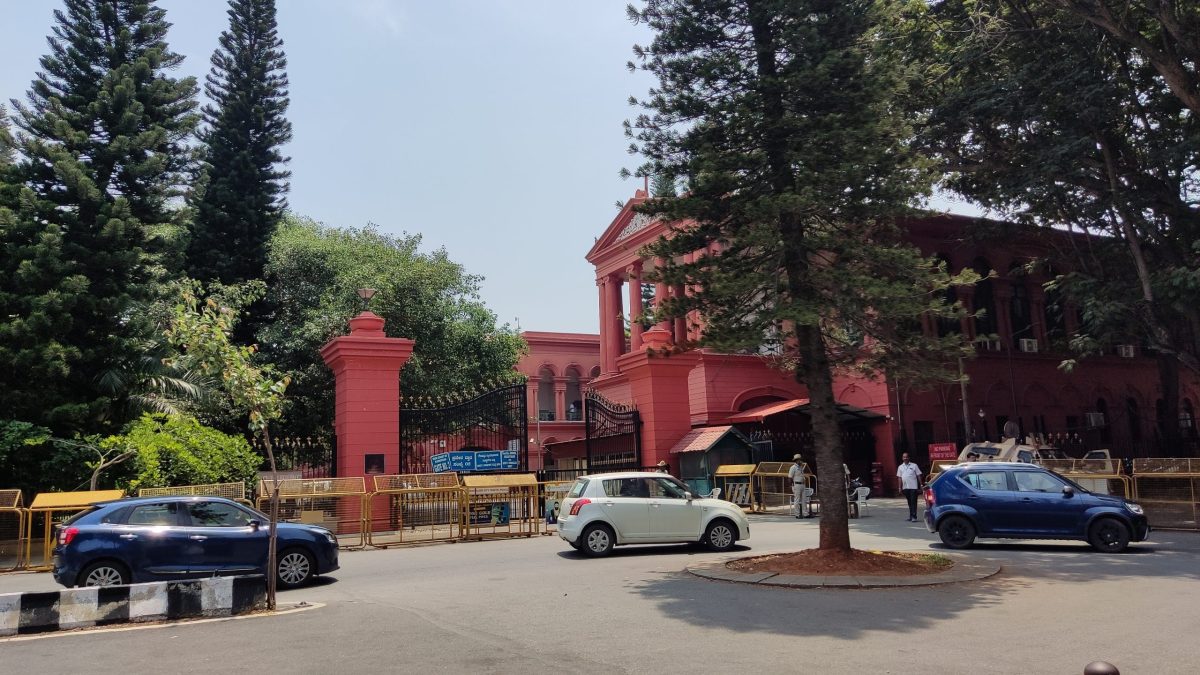 The red High Court of Karnataka building seen across a road in Bengaluru