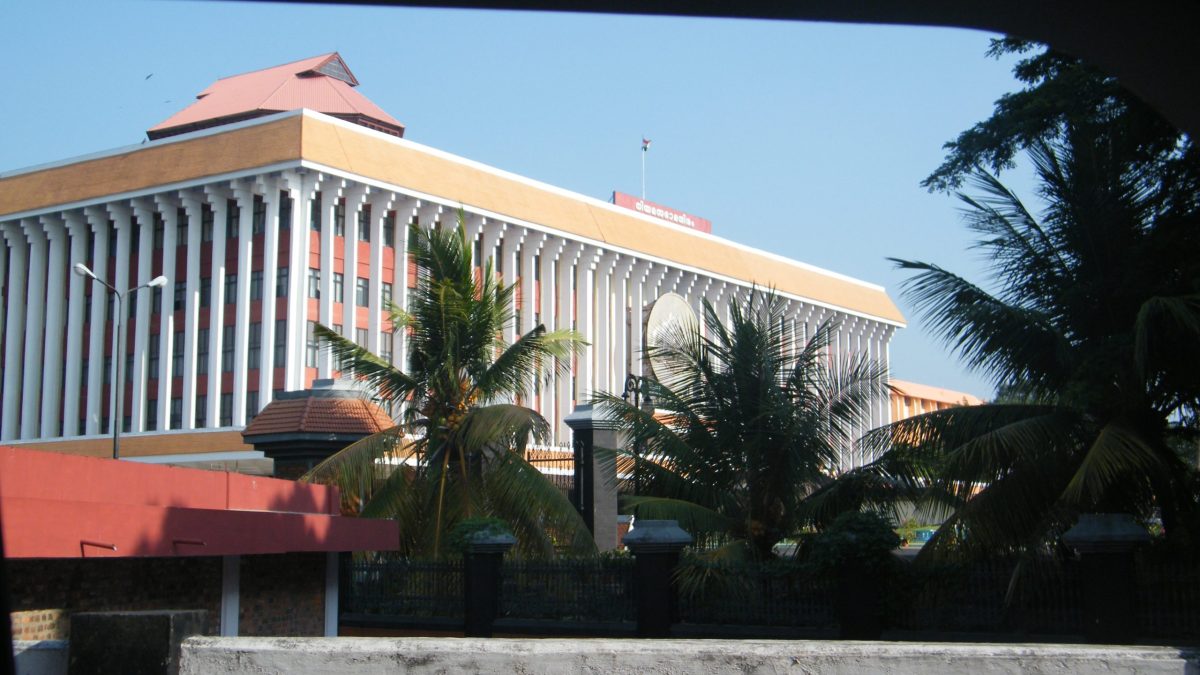The Kerala Legislative Assembly building in Thiruvananthapuram seen through palm trees