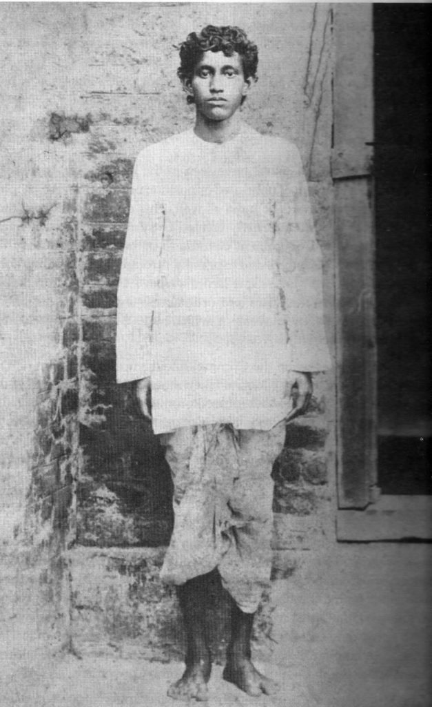 Full-length photograph of the teenage Khudiram Bose standing in a white shirt and dhoti