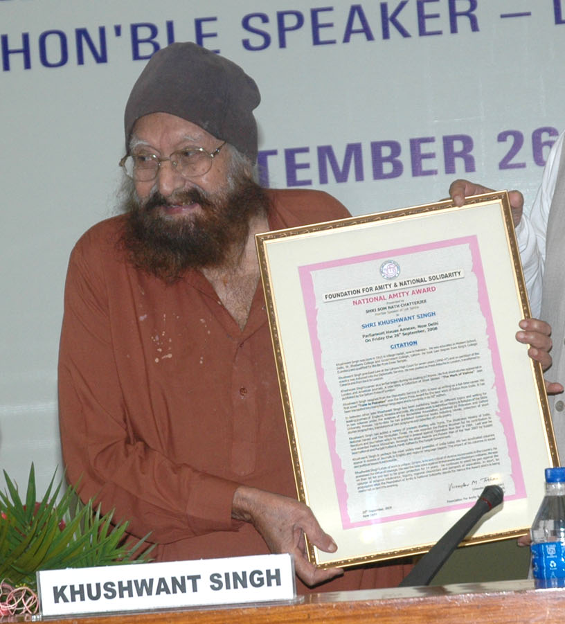 Khushwant Singh in a turban holding a framed citation