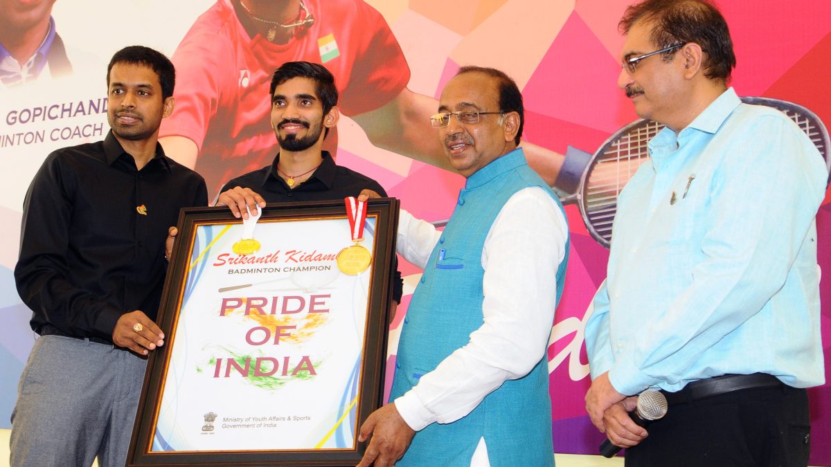 Kidambi Srikanth holding a framed Pride of India memento with coach Pullela Gopichand and Sports Minister Vijay Goel