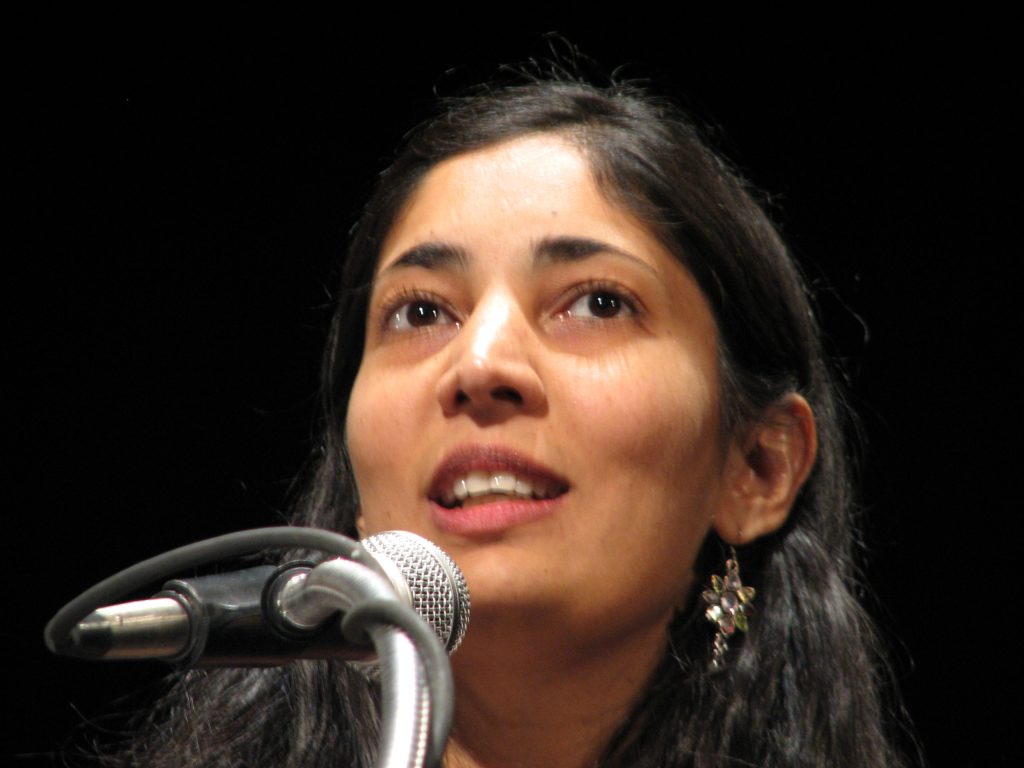 Close-up of Kiran Desai looking upward as she speaks at a microphone