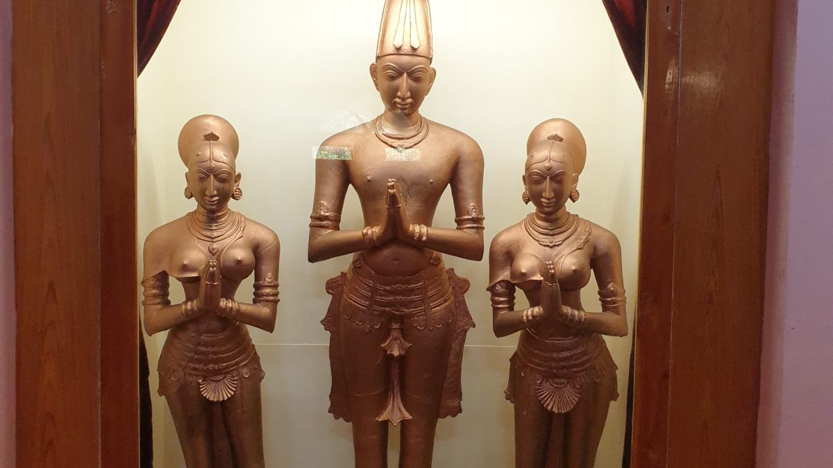 A framed photograph of the statues of Krishnadevaraya standing between his two queens