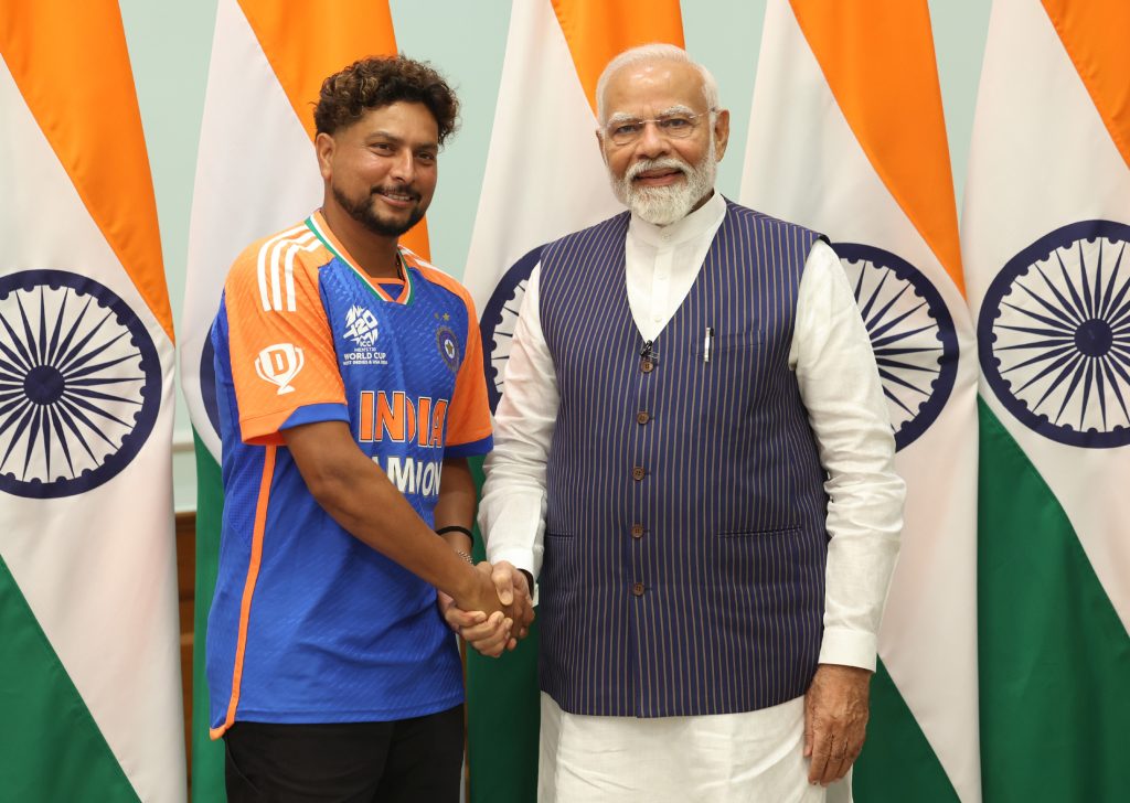 Kuldeep Yadav in India's champions jersey shaking hands with Prime Minister Narendra Modi