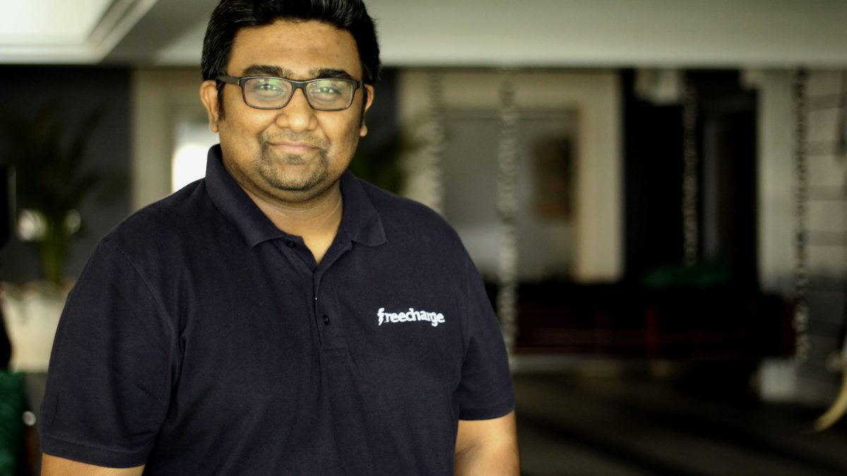 Kunal Shah in glasses and a dark FreeCharge polo shirt, smiling