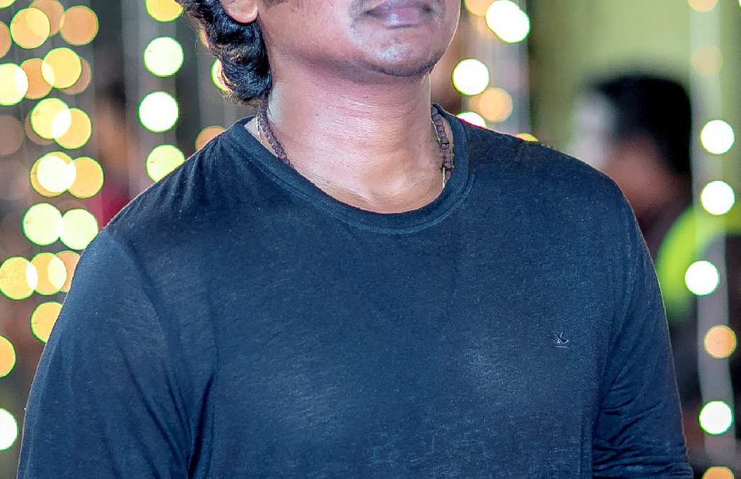 Lokesh Kanagaraj with curly hair, in a blue sweatshirt, at an awards event