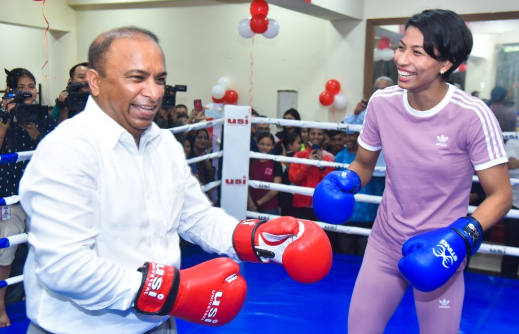 Lovlina Borgohain smiling in boxing gloves in a ring with an official